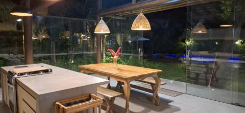 a kitchen with a table and a counter with a stove at Villa do Cajueiro Imbassaí in Imbassai