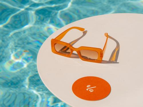 a pair of glasses sitting on a plate next to a pool at Hotel Alba Adelaide in Adelaide