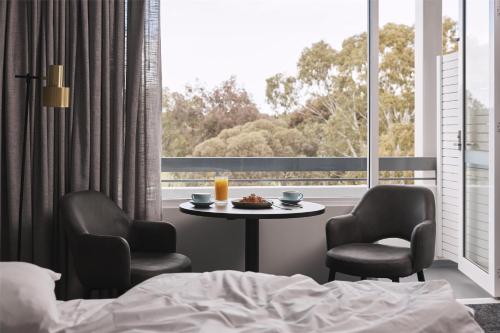 a room with a table and two chairs and a window at Hotel Alba Adelaide in Adelaide