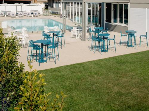 a group of tables and chairs next to a pool at Hotel Alba Adelaide in Adelaide