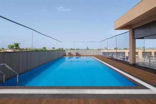 a swimming pool on the roof of a building at Hilton Garden Inn Surat City Centre in Surat