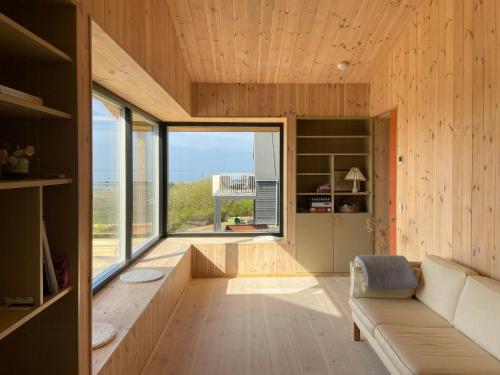 a living room with a couch and a large window at Modern Summer House Overlooking The Water in Faaborg