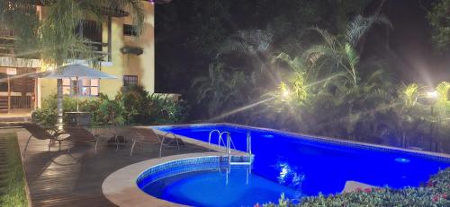 a swimming pool in front of a hotel at night at Villa do Cajueiro Imbassaí in Imbassai