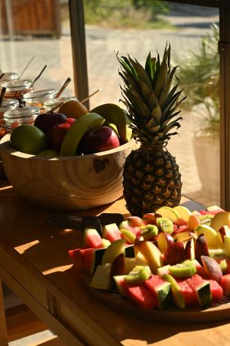a plate of fruit with a pineapple and a bowl of fruit at Del Mare Suites in Glífa