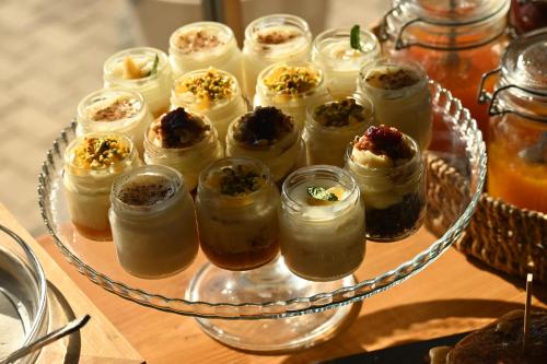 a tray of jam jars filled with desserts on a table at Del Mare Suites in Glífa