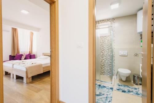a bedroom with a bed and a bathroom with a mirror at Chez Vous in Ulcinj