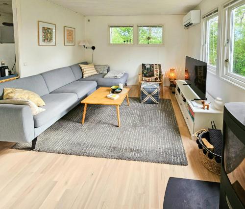 a living room with a couch and a table at Holiday Home With Two Annexes Near The Sejerø Bay in Høve