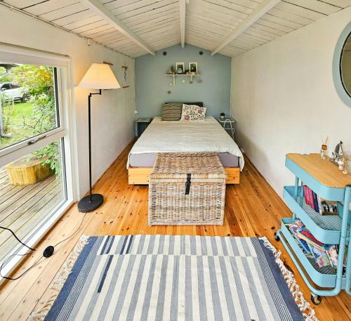a bedroom with a bed and a table and a window at Holiday Home With Two Annexes Near The Sejerø Bay in Høve