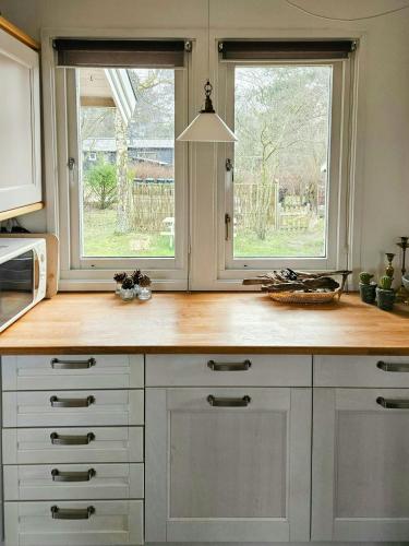 a kitchen with white cabinets and two windows at Holiday Home With Two Annexes Near The Sejerø Bay in Høve