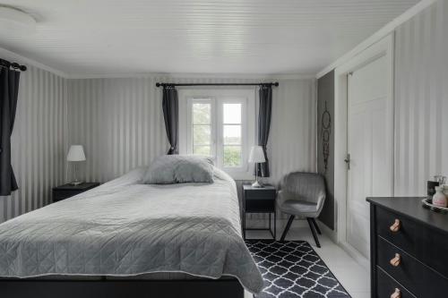 a bedroom with a bed and a chair and a window at Swedish Cottage By Forest And Lake In Småland in Traryd