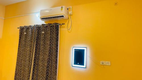 a room with a yellow wall with a heater and a window at KIARSH RESIDENCY HOME Stay in Varanasi