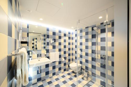 a bathroom with a toilet and a sink and a shower at Placid Hotel Design & Lifestyle Zurich in Zürich