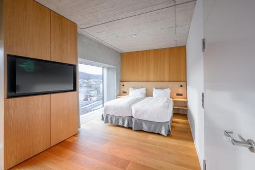 a bedroom with a bed and a flat screen tv at Placid Hotel Design & Lifestyle Zurich in Zürich
