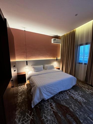 a bedroom with a large bed with white sheets at شقق دخول ذاتي in Taif