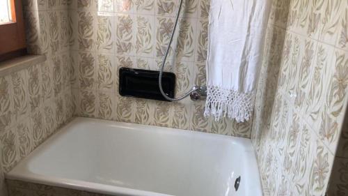a bath tub in a bathroom with a hose on the wall at Campo Felice Casa del Lupo in Collimento