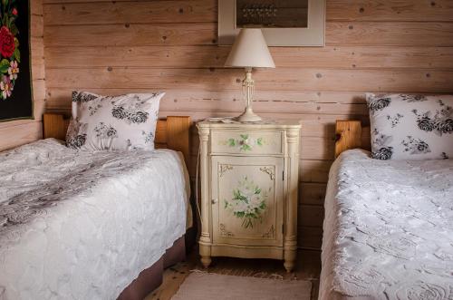 a bedroom with two beds and a lamp on a night stand at Västriku Holiday Home in Nasva