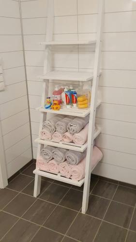 a white shelf with rolls of toilet paper in a bathroom at Cabin In The Archipelago On The Island Kinn in Tansøy