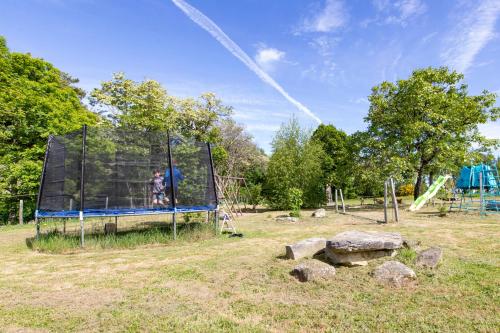 a person on a trampoline in a park at Gîte Chabrignac, jacuzzi et sauna privatif, piscine chauffée partagée, Wifi, salle de jeux in Beynat