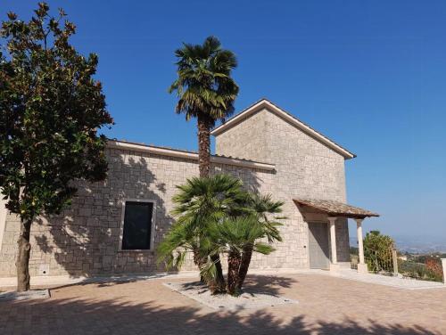 a palm tree in front of a building at Apartment In A Villa In The Green Heart Of Umbria in Stroncone