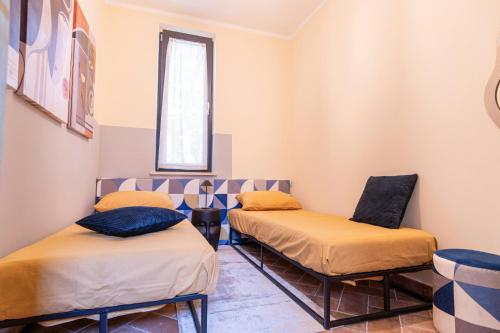 two beds in a room with a window at Apartment In A Villa In The Green Heart Of Umbria in Stroncone