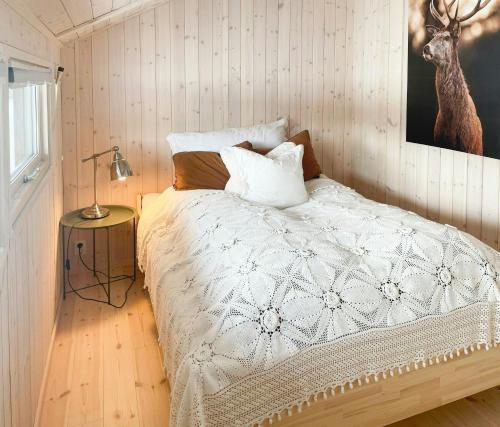 a bedroom with a bed with a white comforter at Cabin With Views In Langsua National Park in Heggenes