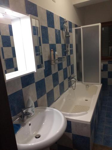 a bathroom with a sink and a shower and a tub at La Marianna in Campo Calabro