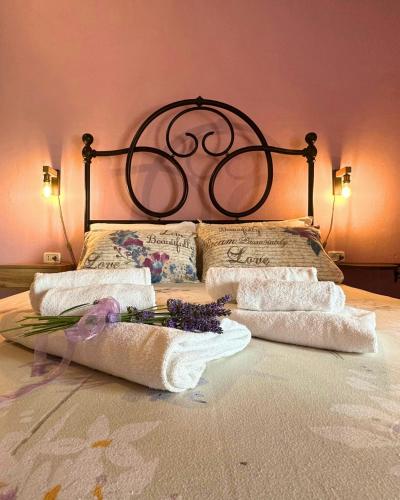 a bed with towels and pillows and flowers on it at Historic Farmhouse In Maremma Countryside in Poggio Murella