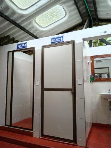 a bathroom with two doors and a sink at Ecohotel Villa Natalia in Boquía