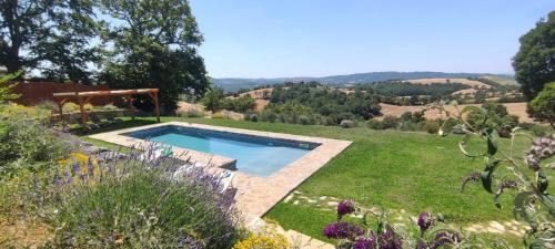 a garden with a swimming pool in the middle of a yard at Historic Farmhouse In Maremma Countryside in Poggio Murella