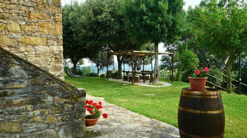 a garden with a picnic table and a wooden barrel at Historic Farmhouse In Maremma Countryside in Poggio Murella