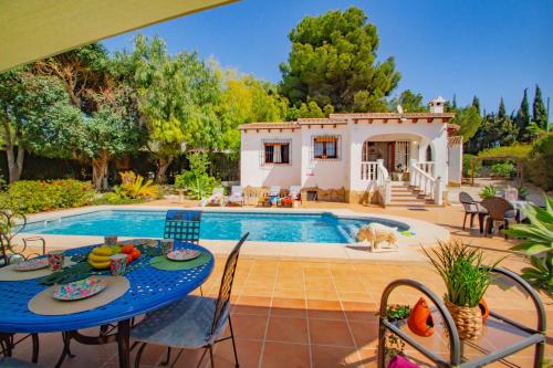 een villa met een zwembad en een tafel en stoelen bij Villa Michele - PlusHolidays in Calpe