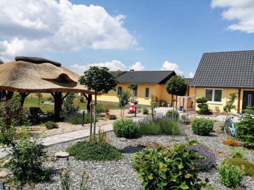 a garden in front of a house at Wohnung Schlafen im Fass mit Sonnenuntergang Blick in Komptendorf