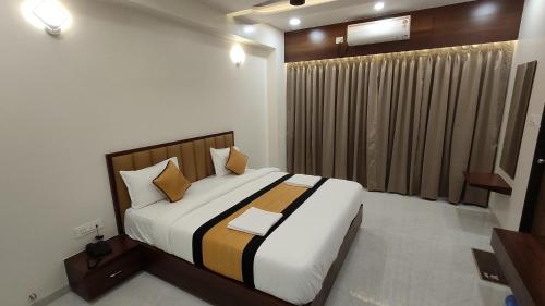 a bedroom with a large bed in a room at Hotel Grand Lushwood in Aurangabad