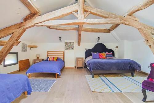 AignesにあるPanoramic Views Of The Pyrenees In Lauragaisのベッドルーム1室(ベッド2台、木製の梁付)