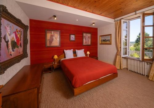 a bedroom with a large bed with red walls at Jardin sur Loire in Blois