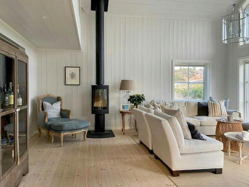 een woonkamer met een bank en een open haard bij Modern Summer House With Pool In Risør in Risør