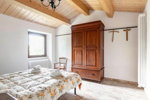 a bedroom with a bed and a wooden cabinet at Ca'Solare Corticelli in San Cristoforo de Valli