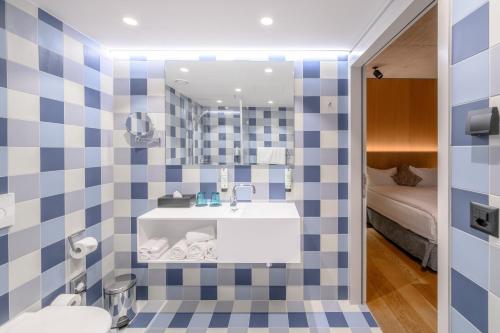 bagno con parete piastrellata in blu e bianco di Placid Hotel Design & Lifestyle Zurich a Zurigo