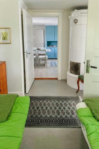a room with two beds and a living room with a table at Traditional Red House By The Lake In Småland in Åby