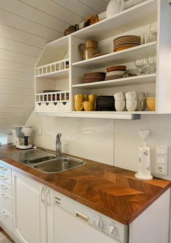 a kitchen with white cabinets and a sink at Traditional Red House By The Lake In Småland in Åby