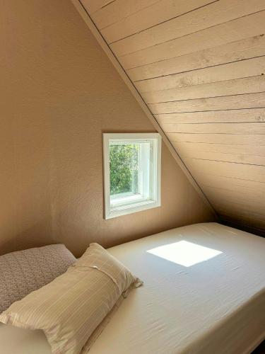 a bed in a room with a window at Views And Calmness In The Heart Of The Småland Forest in Strömsnäsbruk