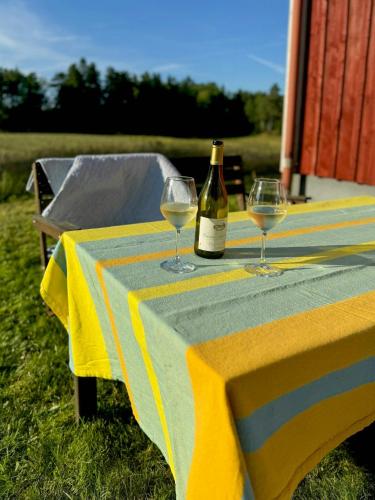 a bottle of wine and two glasses on a table at Views And Calmness In The Heart Of The Småland Forest in Strömsnäsbruk