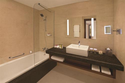 a bathroom with a sink and a shower and a tub at DoubleTree by Hilton Resort & Spa Marjan Island in Ras al Khaimah