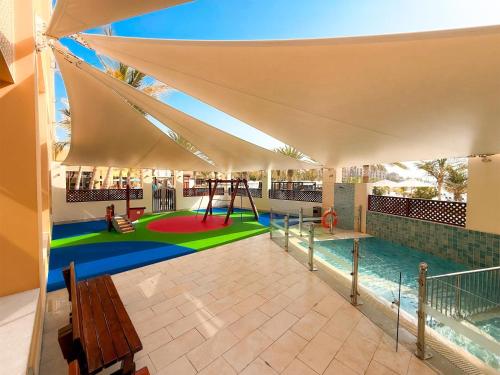 a pavilion with a playground with a swing at DoubleTree by Hilton Resort & Spa Marjan Island in Ras al Khaimah