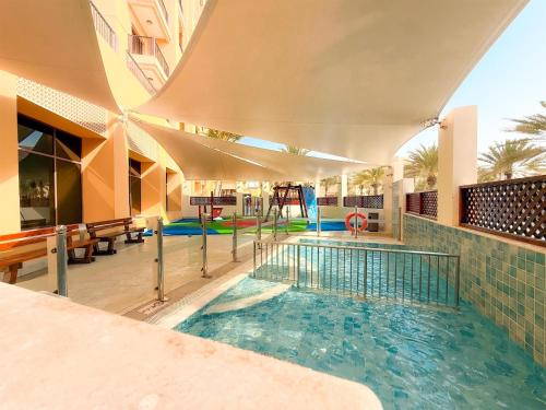 a swimming pool in a building with a playground at DoubleTree by Hilton Resort & Spa Marjan Island in Ras al Khaimah