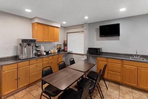 a kitchen with a table and chairs in a room at Travelodge by Wyndham New Braunfels in New Braunfels