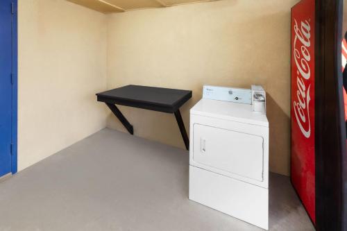 a small room with a white refrigerator and a black table at Travelodge by Wyndham New Braunfels in New Braunfels