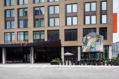 a large building with a sculpture in front of it at Canopy By Hilton Nashville Downtown The Gulch in Nashville