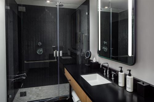 a bathroom with a sink and a glass shower at Canopy By Hilton Nashville Downtown The Gulch in Nashville