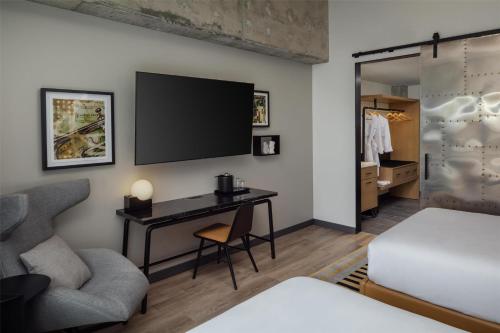 a room with a desk and a television on a wall at Canopy By Hilton Nashville Downtown The Gulch in Nashville